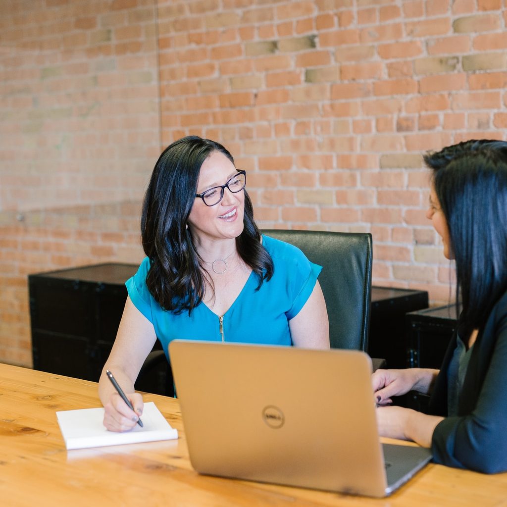 Two women talking while working