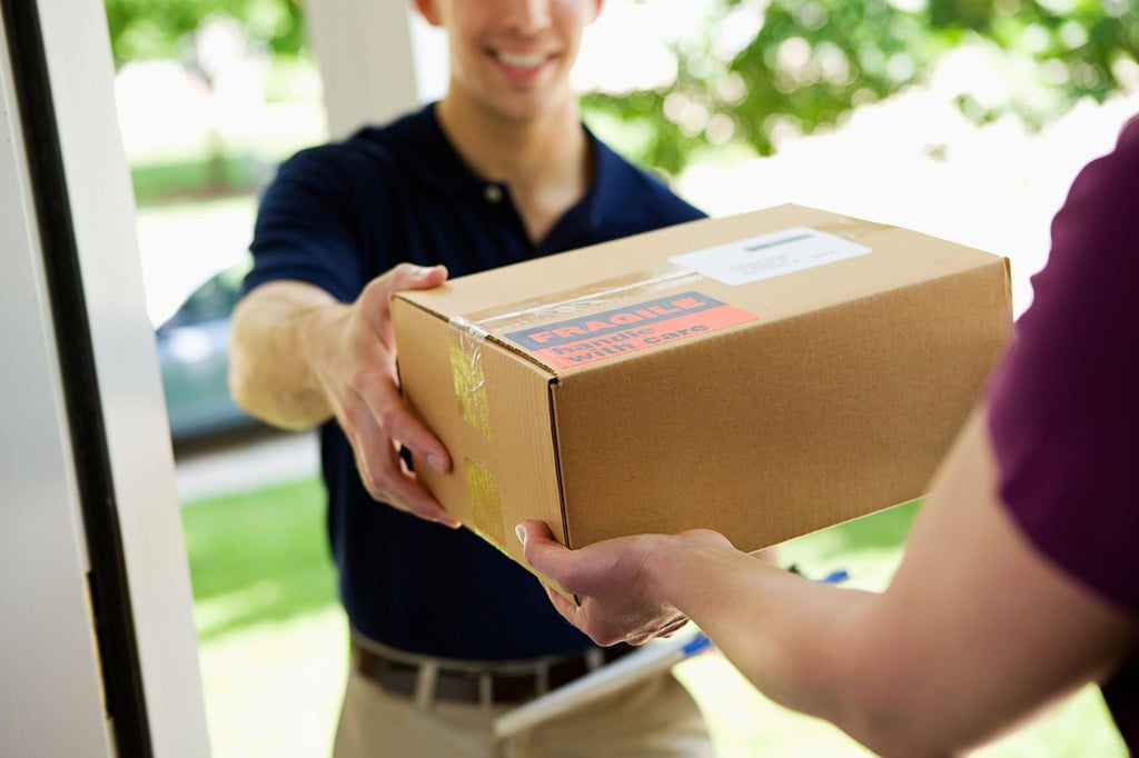 Delivery person handing box to customer