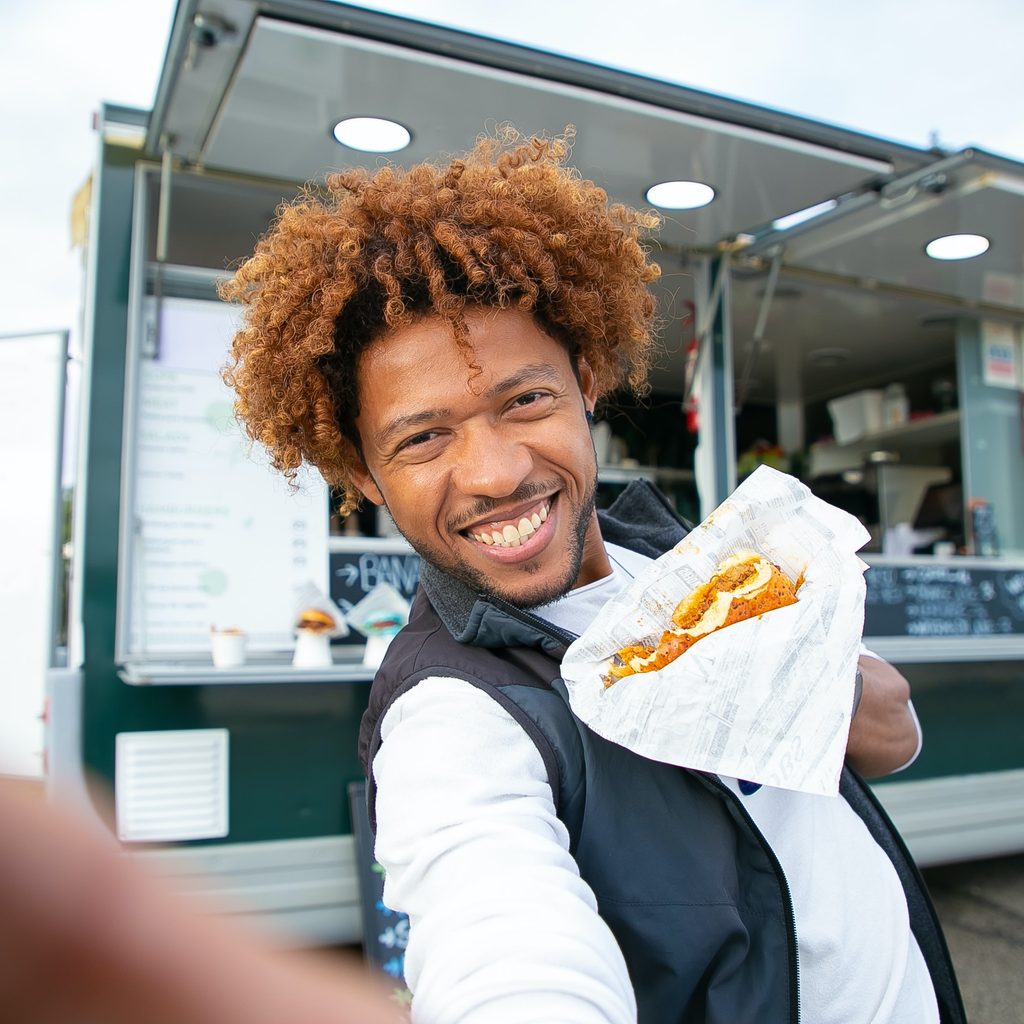 Smiling Black Man Eating A Sandwich