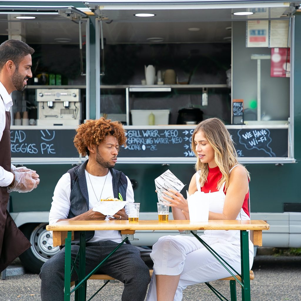 People enjoying lunch near a food truck