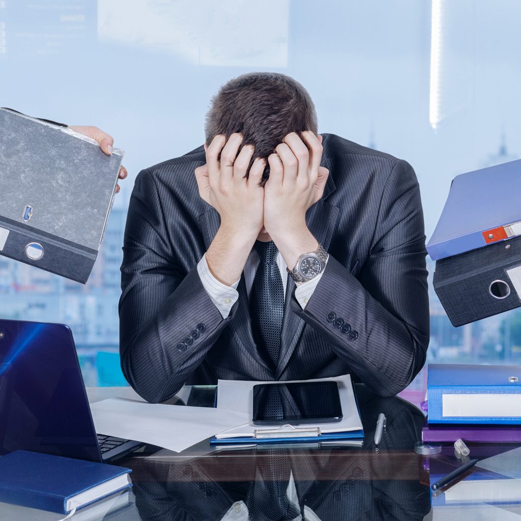 Businessman burying his head in his hands