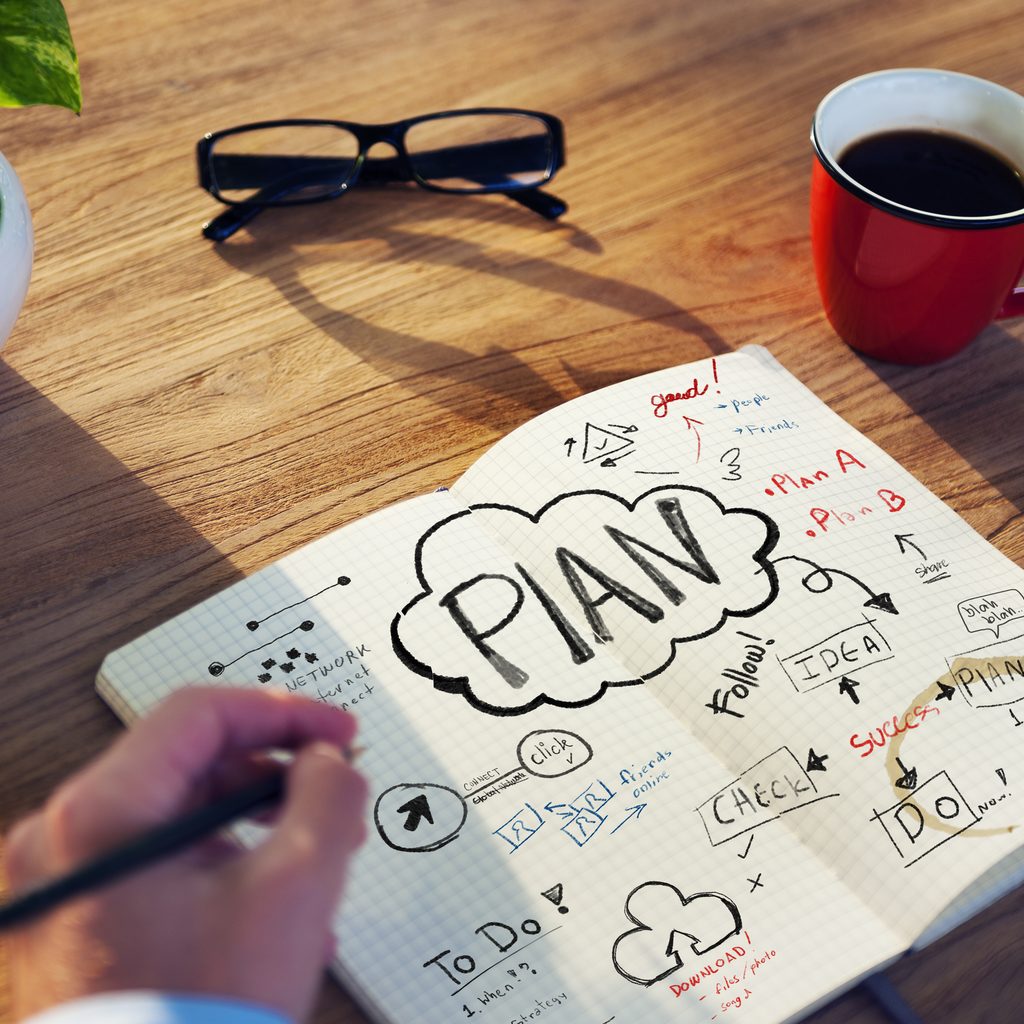 Man's hand drawing business plan graphic