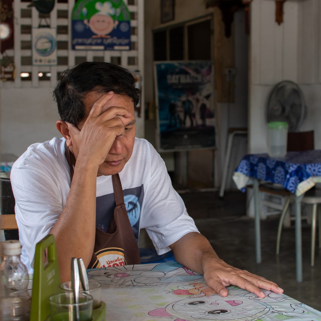 Sad cook sitting at table