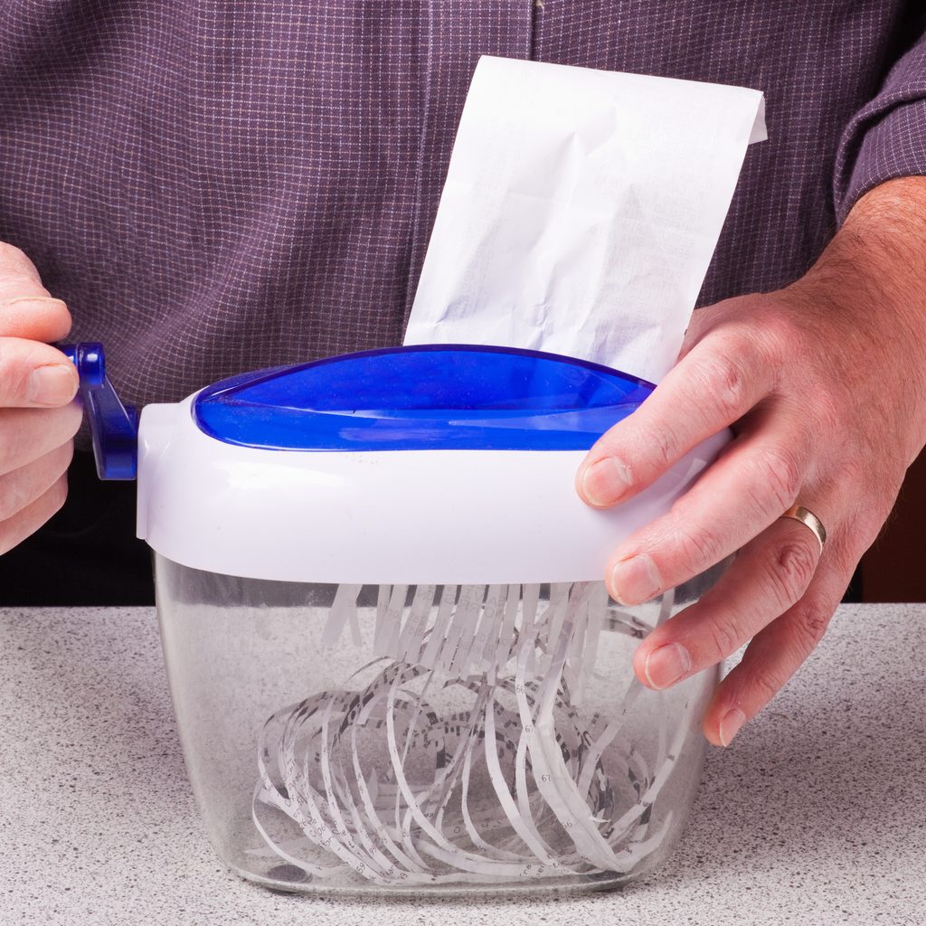 Person using a small paper shredder
