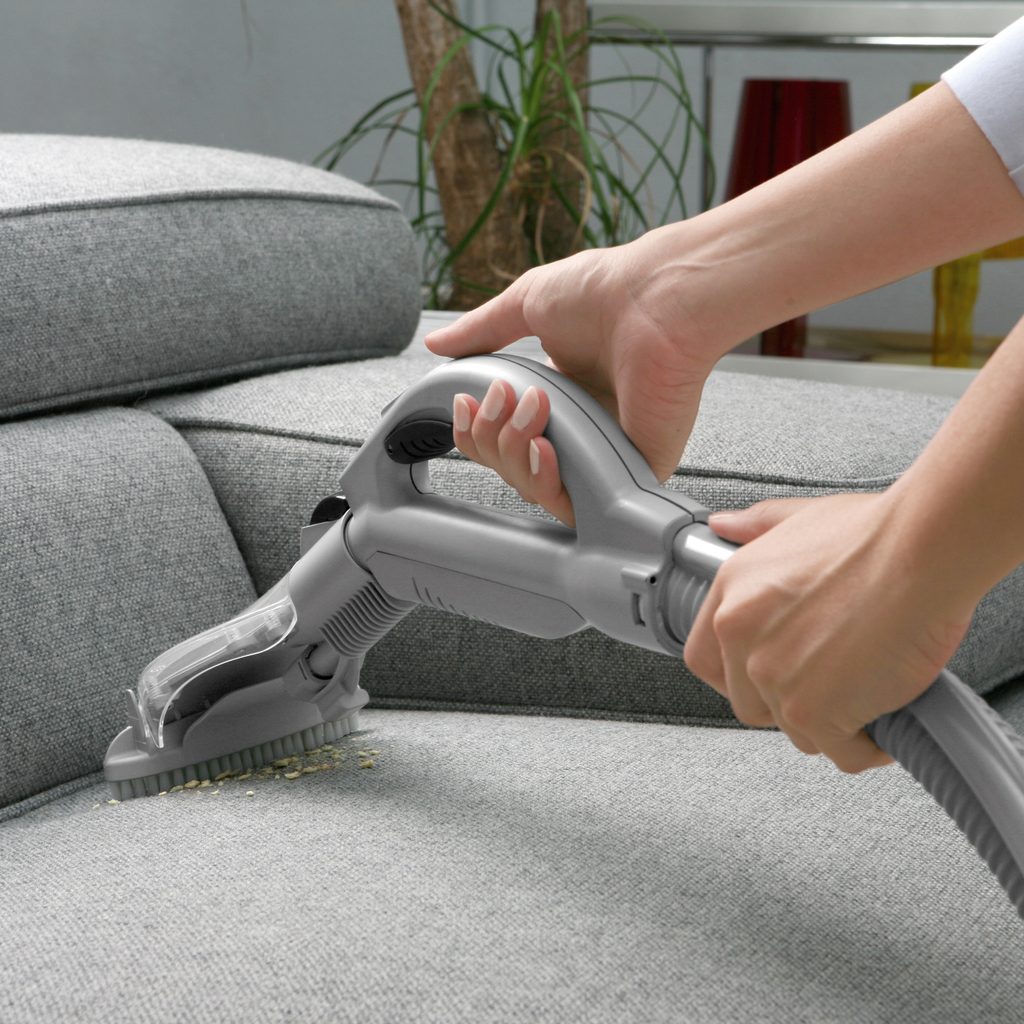 Cleaning the couch with a vacuum