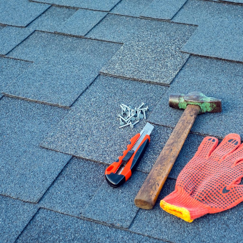 Hammer, nails, and glove on a roof
