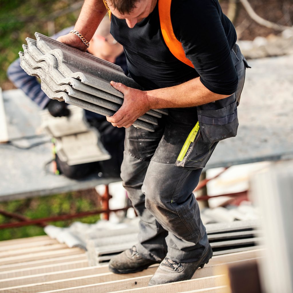 Roofer carrying roof shingles