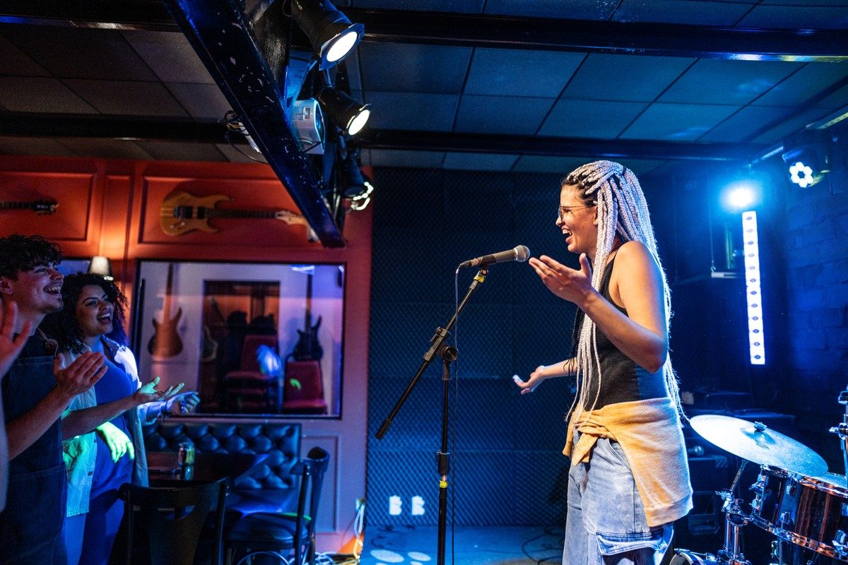 Young woman talking during stand-up comedy show with stage lights