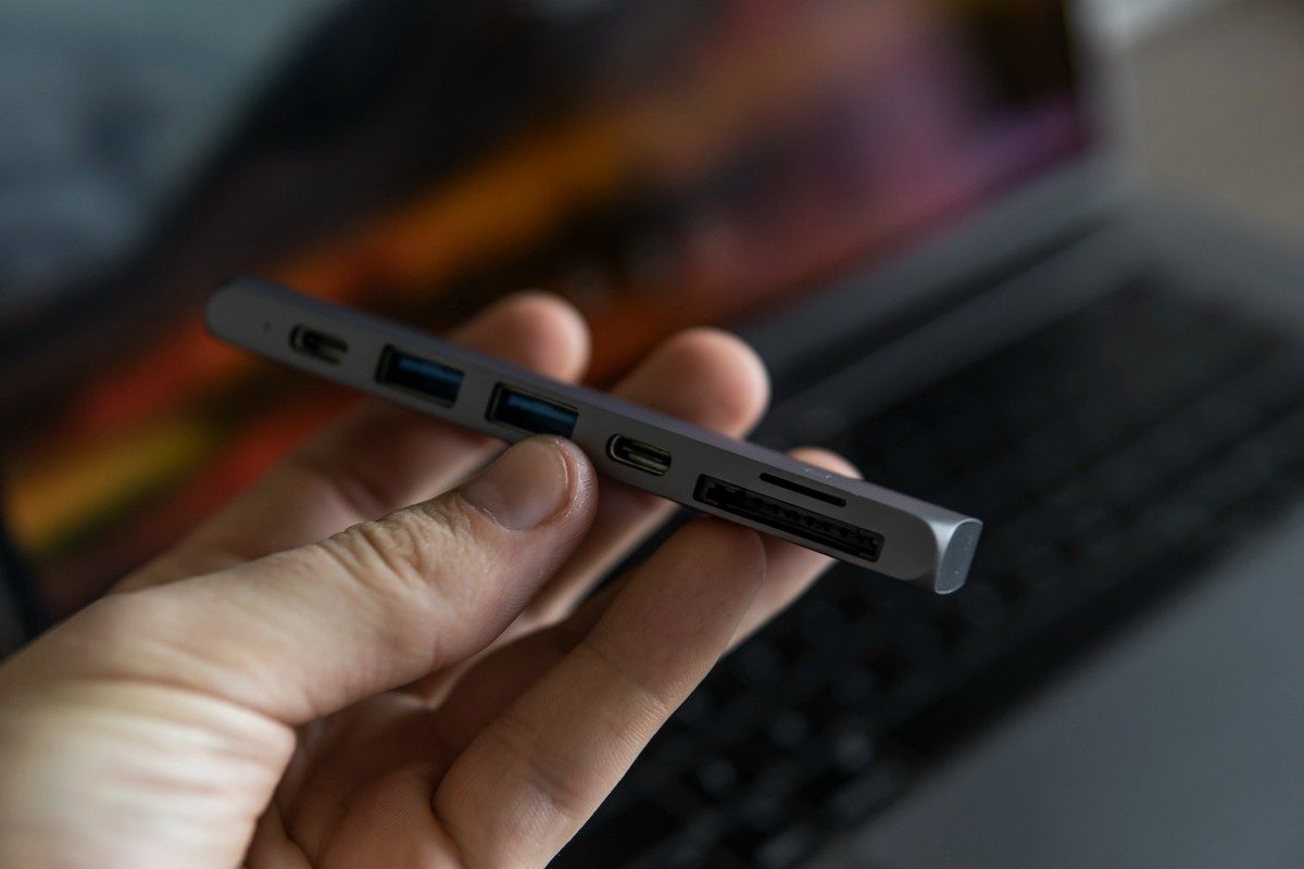 Man's hand holding The USB adapter under the Type-C connector for macbook.