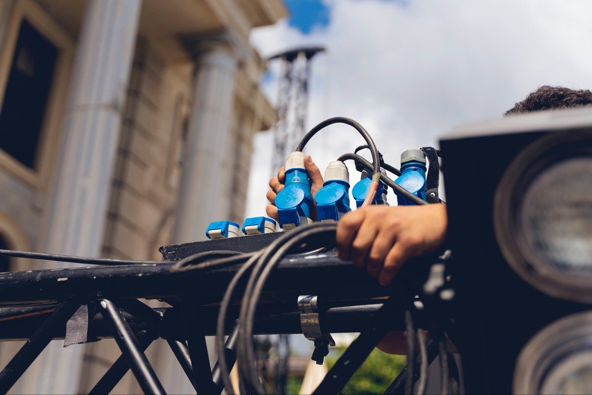 Lighting technician installing professional lighting equipment for concert stage , installation with led lights and projectors