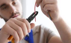 Individual using a wire stripper.