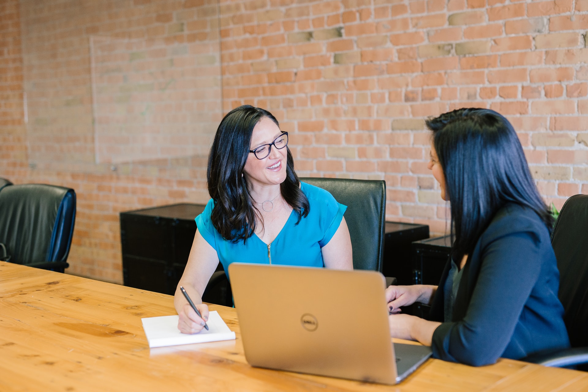 Two women talking while working