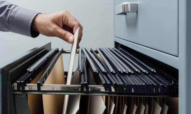 Individual going through file cabinet
