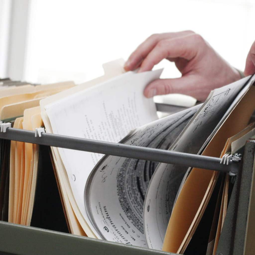 Person looking at papers in filing cabinet