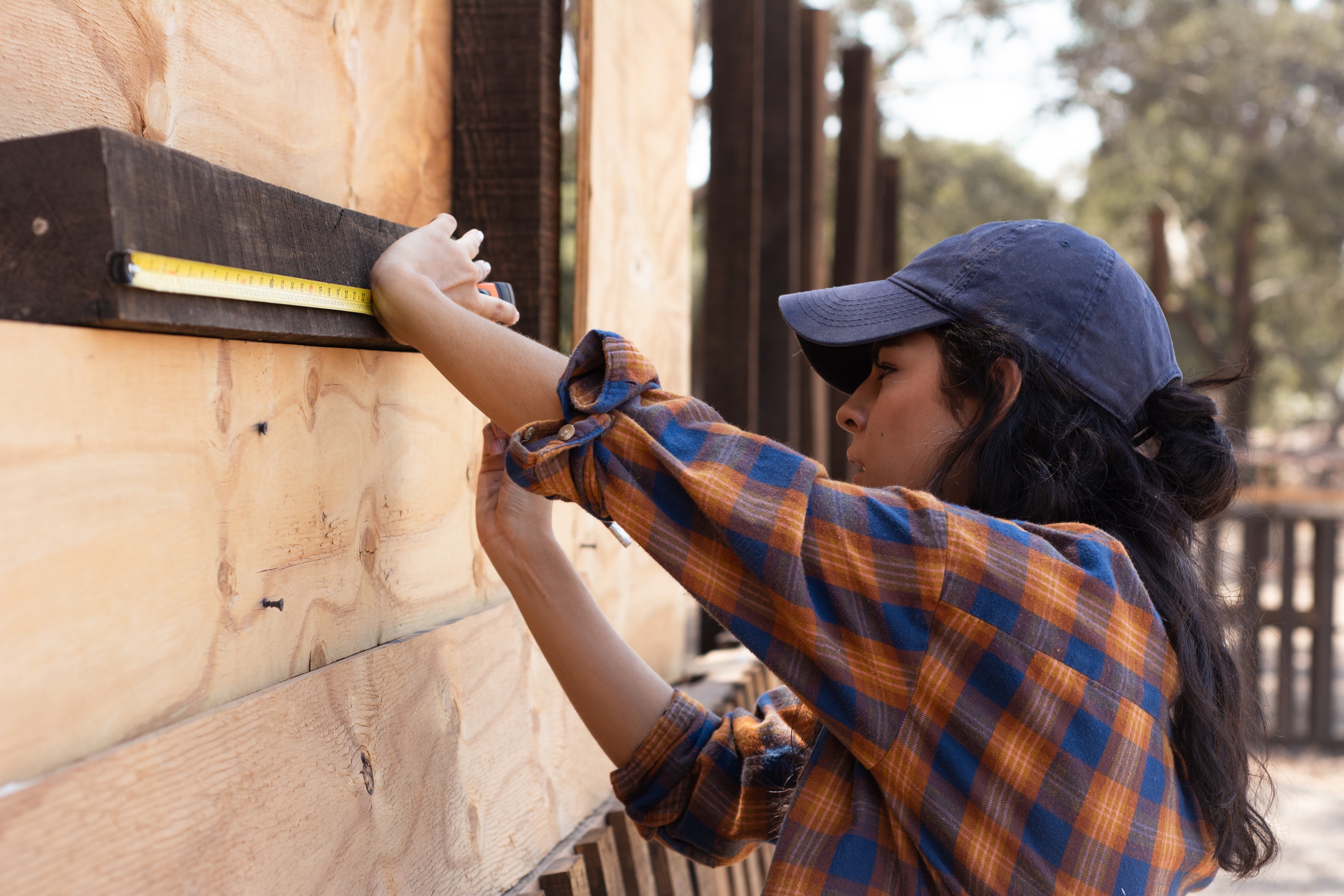 Female carpenter using measuring tape
