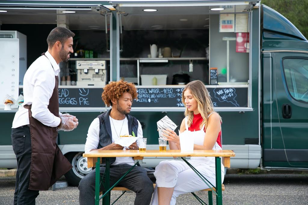 People enjoying lunch near a food truck