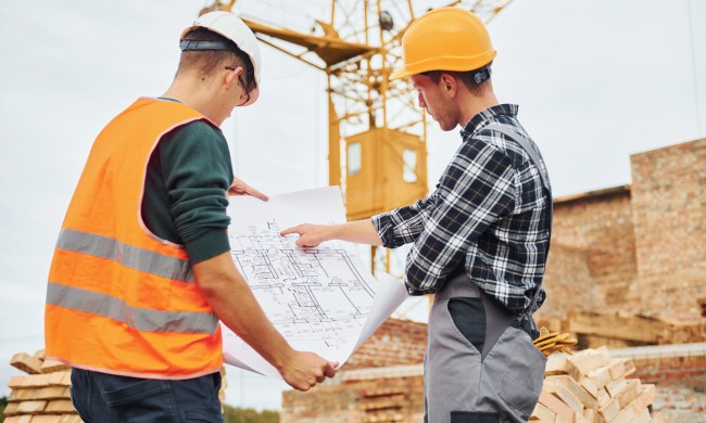 what do construction workers wear using paper document with plan on it  two