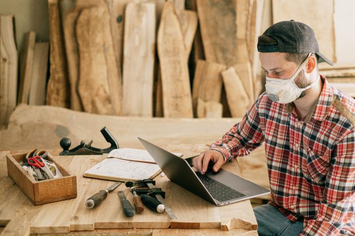 small businesses thriving man using a laptop at wood workshop