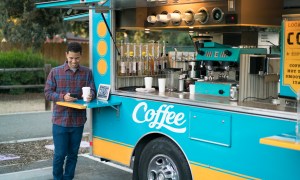 Customer drinking coffee by a food truck