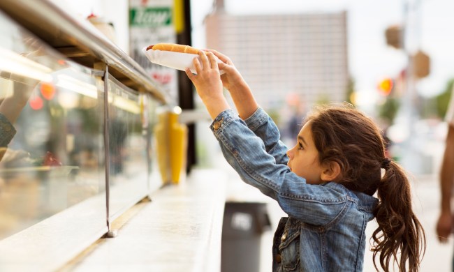 Customer taking down a hot dog from a food truck
