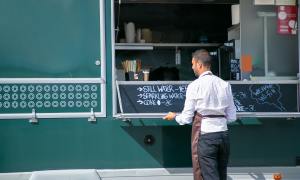 Business owner writing menu for food cart