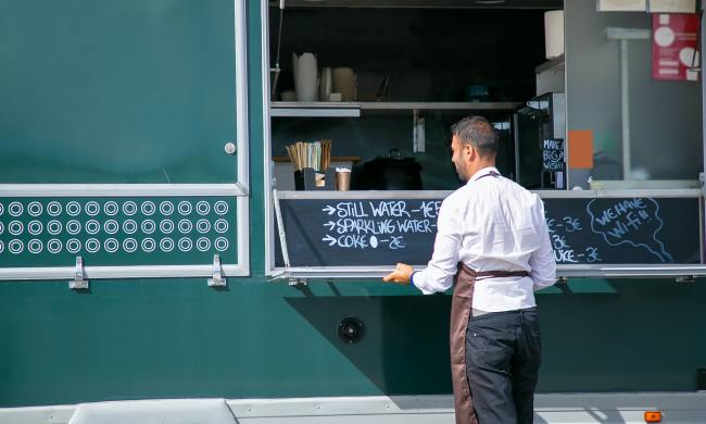 Business owner writing menu for food cart