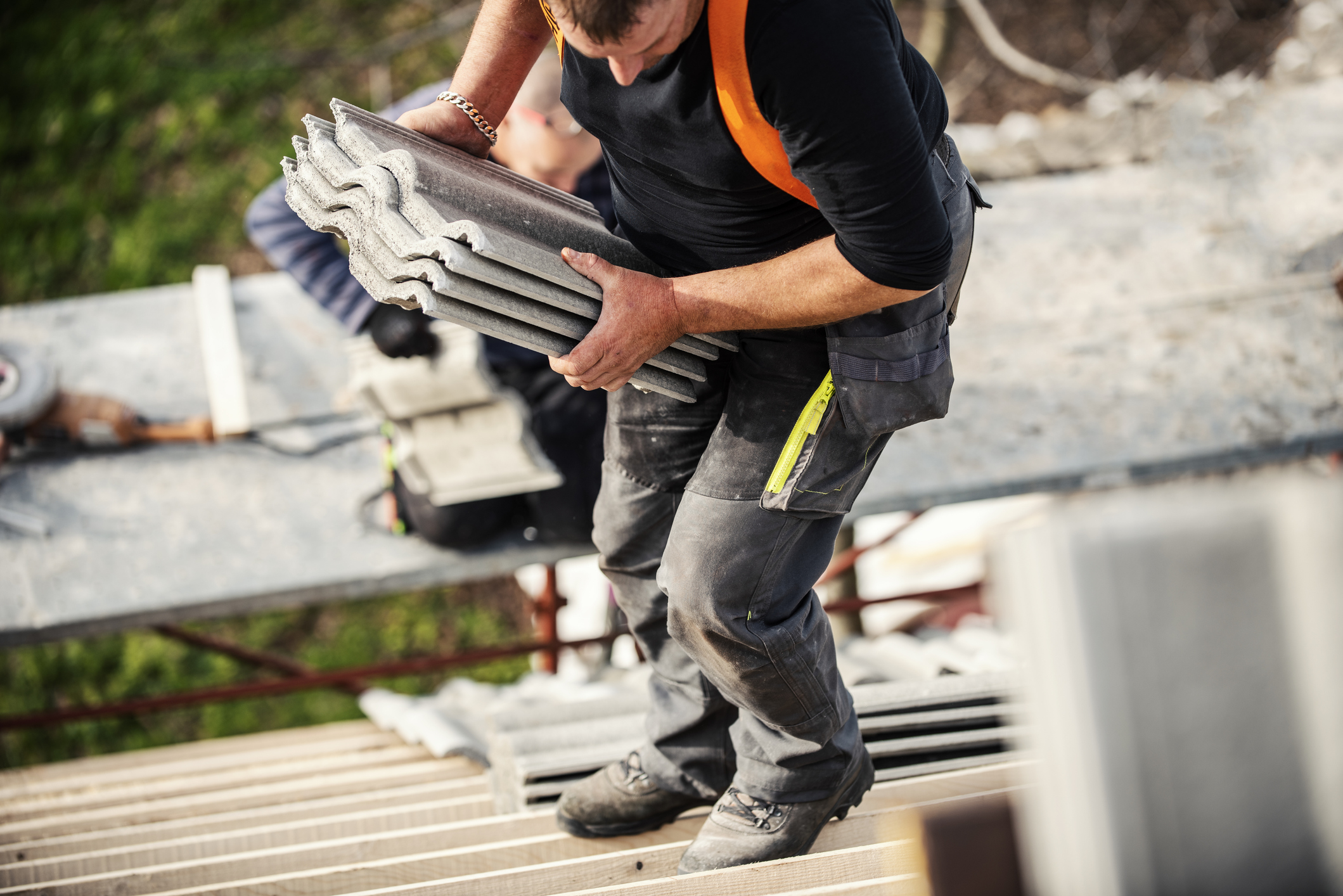 Roofer carrying roof shingles