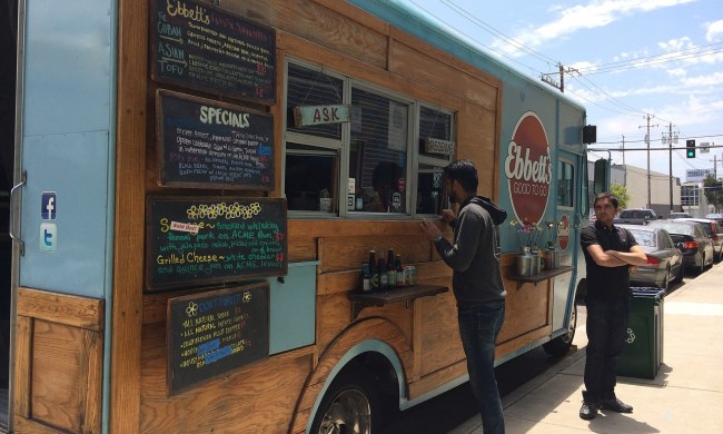 Food truck with menu and person standing out front