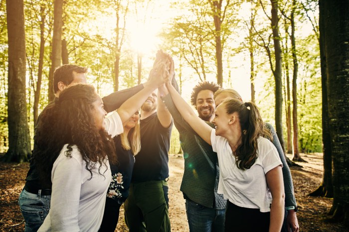 Coworkers high five outdoors on a teambuilding retreat
