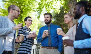 Five coworkers talk in an outdoor area
