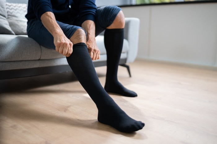A man puts on compression stockings before work