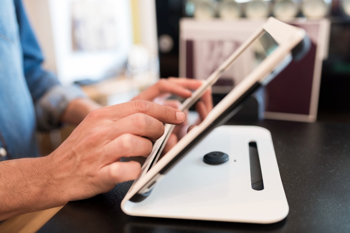 In restaurant the waiter prepares the bill on tablet with stand